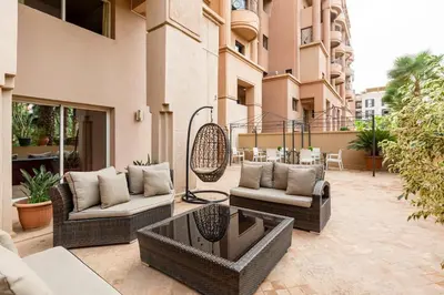 an outdoor patio with wicker chairs and a table at Somptueux Duplex au coeur de l'Hivernage in Marrakech