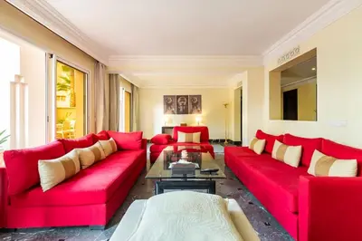 a living room with red couches and a table at Somptueux Duplex au coeur de l'Hivernage in Marrakech