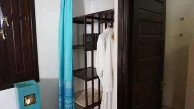 a closet with a white robe on a rack at RIAD KALE POLIS in Marrakech