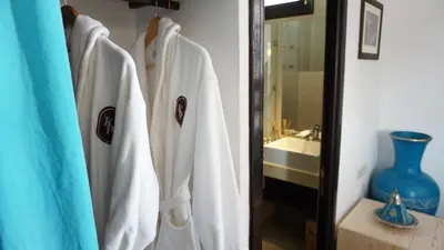 a group of white robes hanging in a bathroom at RIAD KALE POLIS in Marrakech