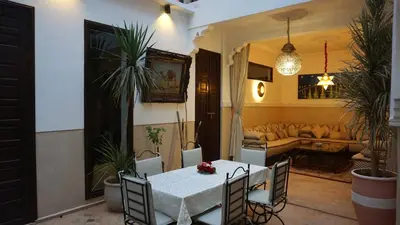 a dining room with a table and chairs and a couch at RIAD KALE POLIS in Marrakech