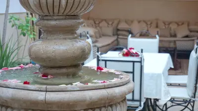 a stone fountain with flowers on it in a patio at RIAD KALE POLIS in Marrakech