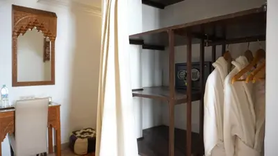 a room with a closet with wooden shelves and a mirror at RIAD KALE POLIS in Marrakech