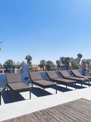 a row of benches sitting on top of a pool at Perfect home in Marrakech in Marrakech