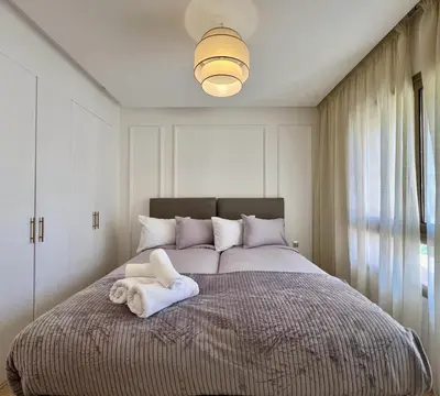 a bedroom with a large bed with towels on it at Prestigia Luxury Appart 2 Room in Marrakech
