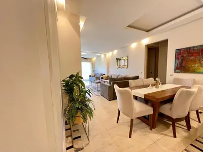 a living room with a table and chairs and a couch at Prestigia Luxury Appart 2 Room in Marrakech