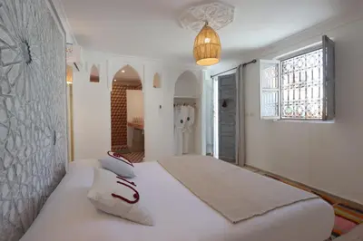a bedroom with a large white bed with a window at Riad Pop, a haven in the heart of the Medina in Marrakech