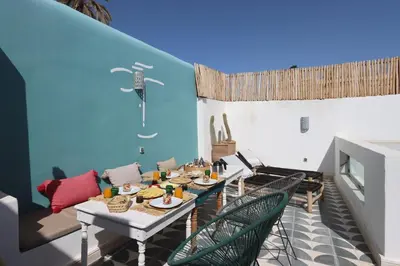 a room with a table and chairs and a blue wall at Riad Pop, a haven in the heart of the Medina in Marrakech