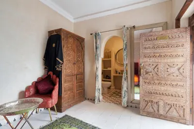 a room with a red chair and an open door at Riad La Fayette Bed & Breakfast in Marrakech