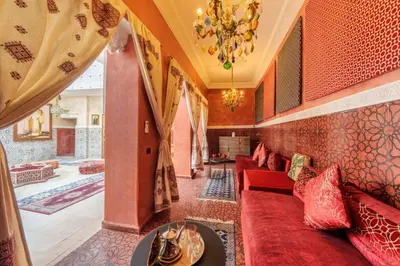 a living room with red couches and a chandelier at Riad La Fayette Bed & Breakfast in Marrakech