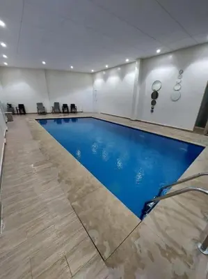 a large swimming pool in a room at Charm Apartment in Marrakech in Marrakech