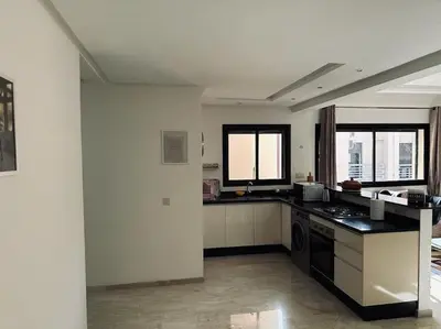 a kitchen with black and white counters and windows at Charm Apartment in Marrakech in Marrakech