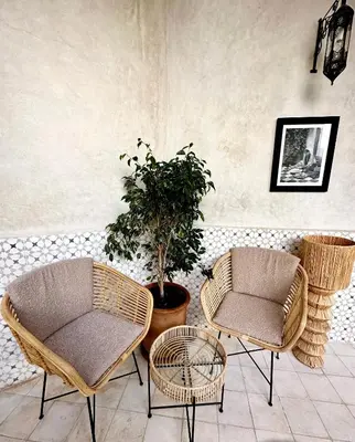 three rattan chairs and a table and a plant at Riad Citrus By La Siredrah in Marrakech