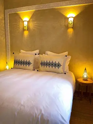 a large bed with white pillows in a room at Riad Citrus By La Siredrah in Marrakech