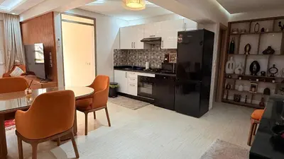 a kitchen with a table and a black refrigerator at LA FINCA DE MARRAKECH in Marrakech