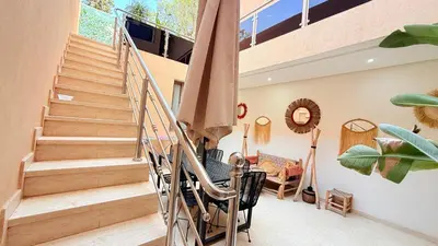 a staircase in a house with a table and chairs at LA FINCA DE MARRAKECH in Marrakech