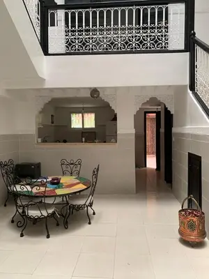 a dining room with a table and chairs and a staircase at Riad lalla aicha in Marrakech