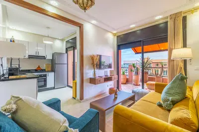 a living room with a couch and a kitchen at Le Jasmin - Appartement Authentique à Gueliz in Marrakech
