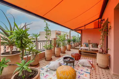 an outdoor patio with potted plants on a balcony at Le Jasmin - Appartement Authentique à Gueliz in Marrakech