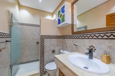 a bathroom with a sink and a shower and a toilet at L'Atlas - Appartement Authentique à Gueliz in Marrakech