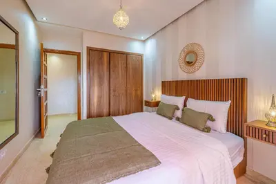 a bedroom with a large bed and a mirror at L'Atlas - Appartement Authentique à Gueliz in Marrakech