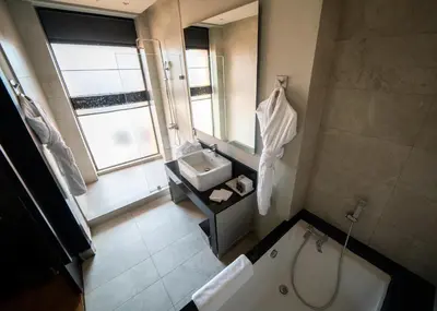 a bathroom with a tub and a sink and a mirror at Hotel Le Rocher Marrakech in Marrakech
