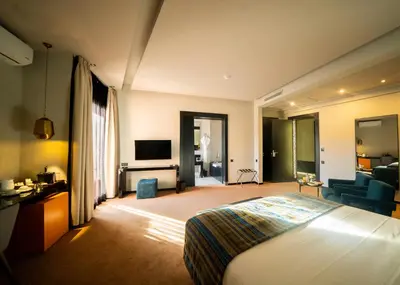 a hotel room with a bed and a television at Hotel Le Rocher Marrakech in Marrakech