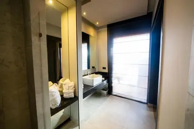 a bathroom with a sink and a mirror at Hotel Le Rocher Marrakech in Marrakech