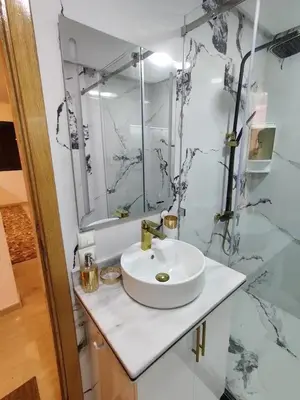 a white bathroom with a sink and a mirror at Modern-elegant Appartement in het centrum in Marrakech