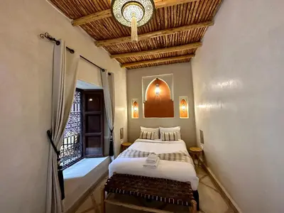 a bedroom with a bed and a window and a ceiling at Riad Sakura Marrakech in Marrakech