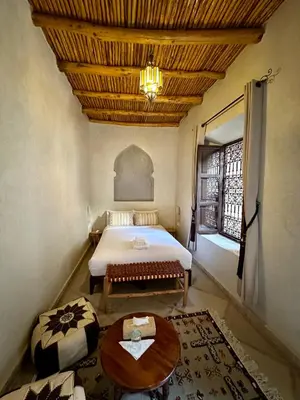 a bedroom with a bed and a wooden ceiling at Riad Sakura Marrakech in Marrakech