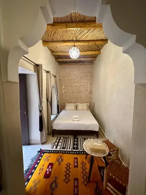 a bedroom with a bed and a table in a room at Riad Sakura Marrakech in Marrakech