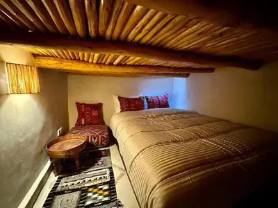 a bedroom with a bed and a table and a chair at Riad Sakura Marrakech in Marrakech