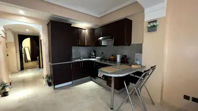 a kitchen with dark brown cabinets and a table at Perle en plein Gueliz in Marrakech