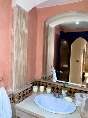 a bathroom with a sink and a large mirror at Perle en plein Gueliz in Marrakech