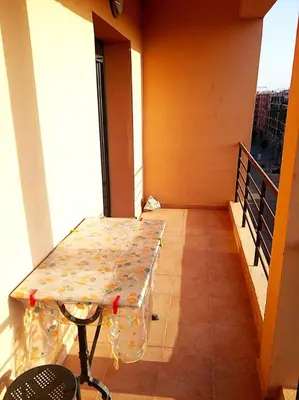 a small table in a room with a balcony at Votre appartement d'exception in Marrakech