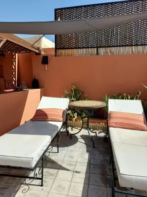 a patio with two beds and a table on a patio at Riad Sophora - Peaceful Heaven in Marrakech in Marrakech