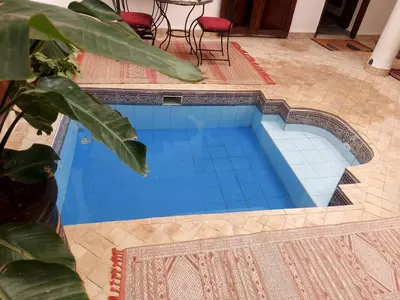 a swimming pool with blue tiles on the floor at Riad Sophora - Peaceful Heaven in Marrakech in Marrakech