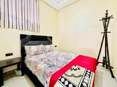 a bedroom with a bed and a tripod at Famille Hanae appartement avec terasse in Marrakech