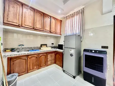 a kitchen with wooden cabinets and a refrigerator at Famille Hanae appartement avec terasse in Marrakech