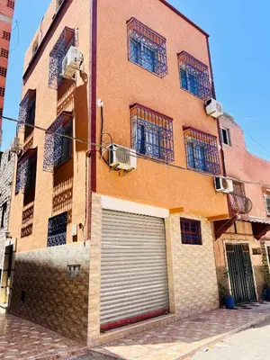 a building with a garage door on the side of it at Famille Hanae appartement avec terasse in Marrakech
