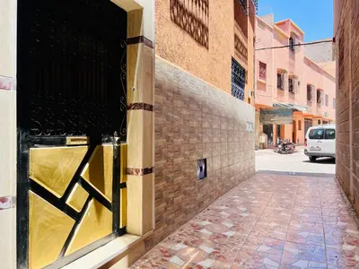 an open door to a building with a brick street at Famille Hanae appartement avec terasse in Marrakech