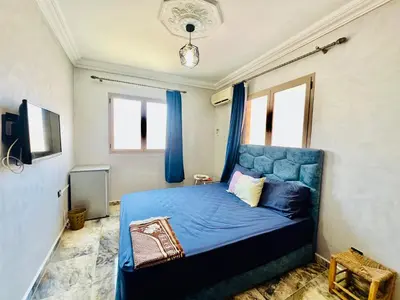 a bedroom with a blue bed with blue curtains at Familiale Chambre calm wifi Hanae in Marrakech