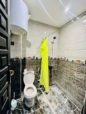 a bathroom with a toilet in a tiled room at Familiale Chambre calm wifi Hanae in Marrakech