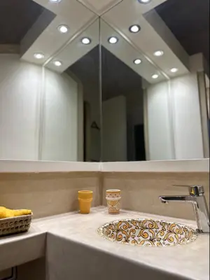 a bathroom counter with a sink with a mirror at Riad Kamilyes in Marrakech