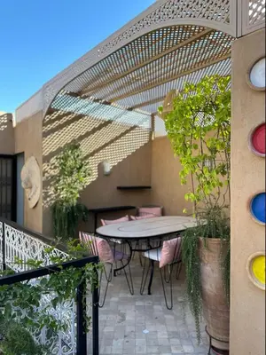 a patio with a table and chairs on a balcony at Riad Kamilyes in Marrakech