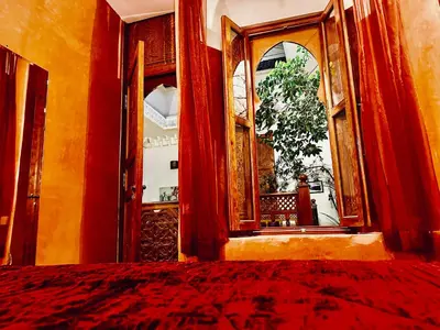 a room with a bed and a large mirror at Riad Radia in Marrakech
