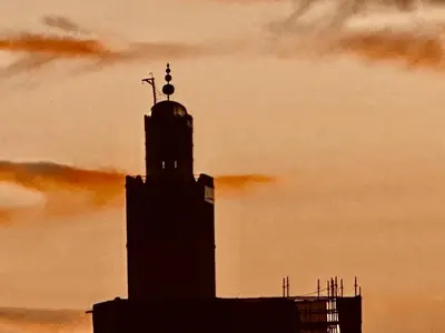 a silhouette of a building with a clock tower at Riad Radia in Marrakech