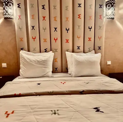 a bedroom with a bed with crosses on the wall at Riad Radia in Marrakech