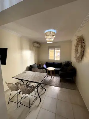 a living room with a table and chairs and a couch at NS 36 by Majestic Properties in Marrakech